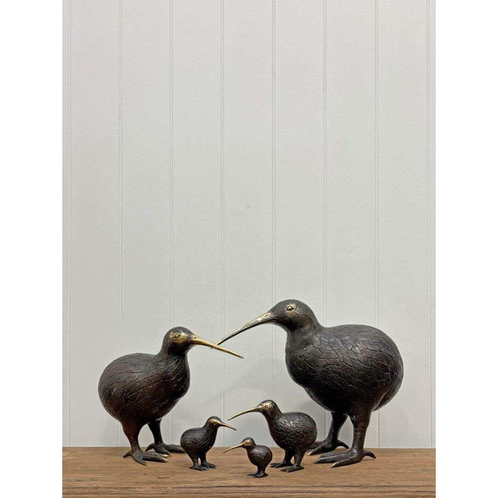 Brass kiwi ornaments in a row on a shelf
