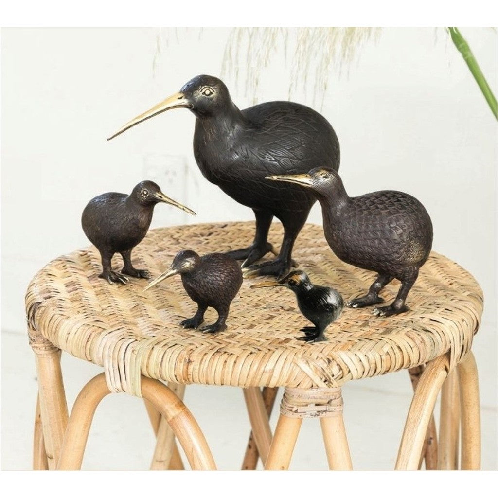 Brass kiwi family displayed on a rattan stool