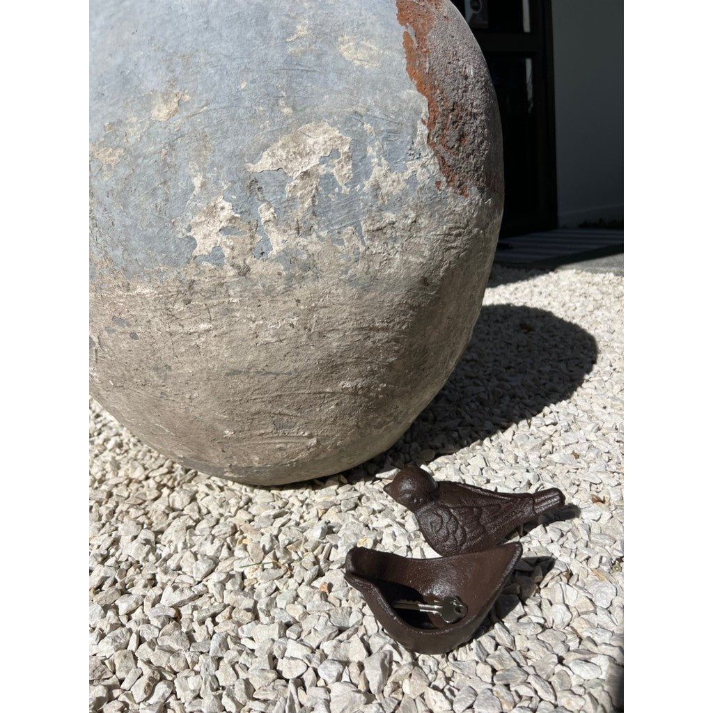 Cast iron birds beside a stone sphere in the garden