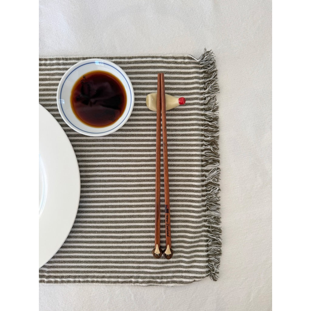 Kiwi chopsticks on a table setting with a dipping bowl