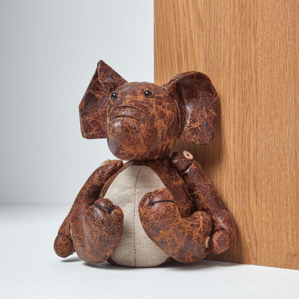 Leather elephant doorstop holding a door open