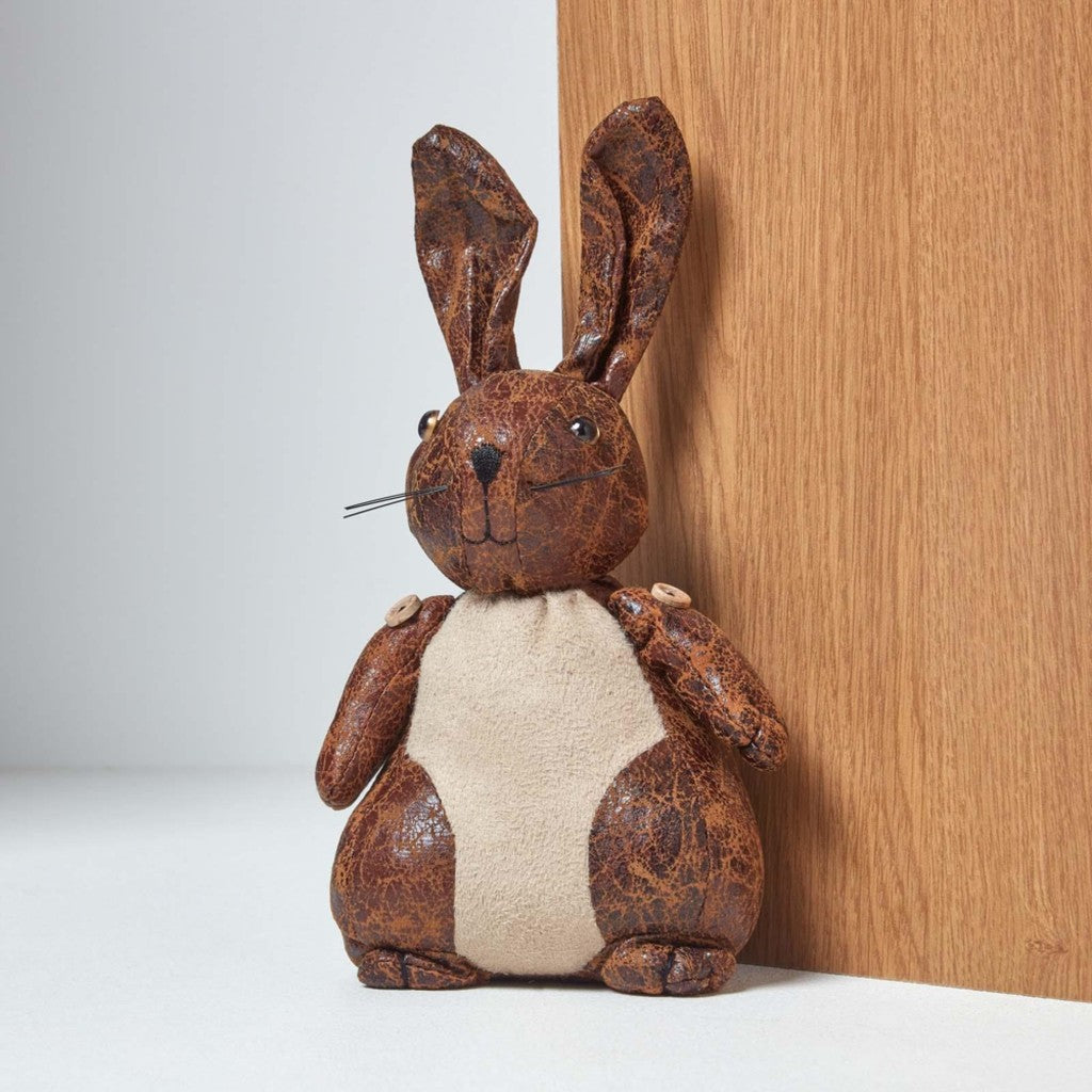 Leather rabbit doorstop holding a door open