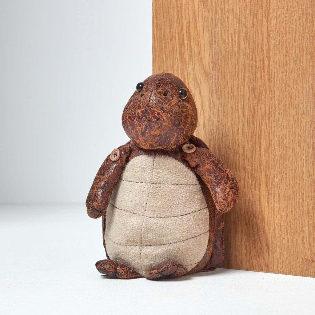 Leather turtle doorstop holding a door open