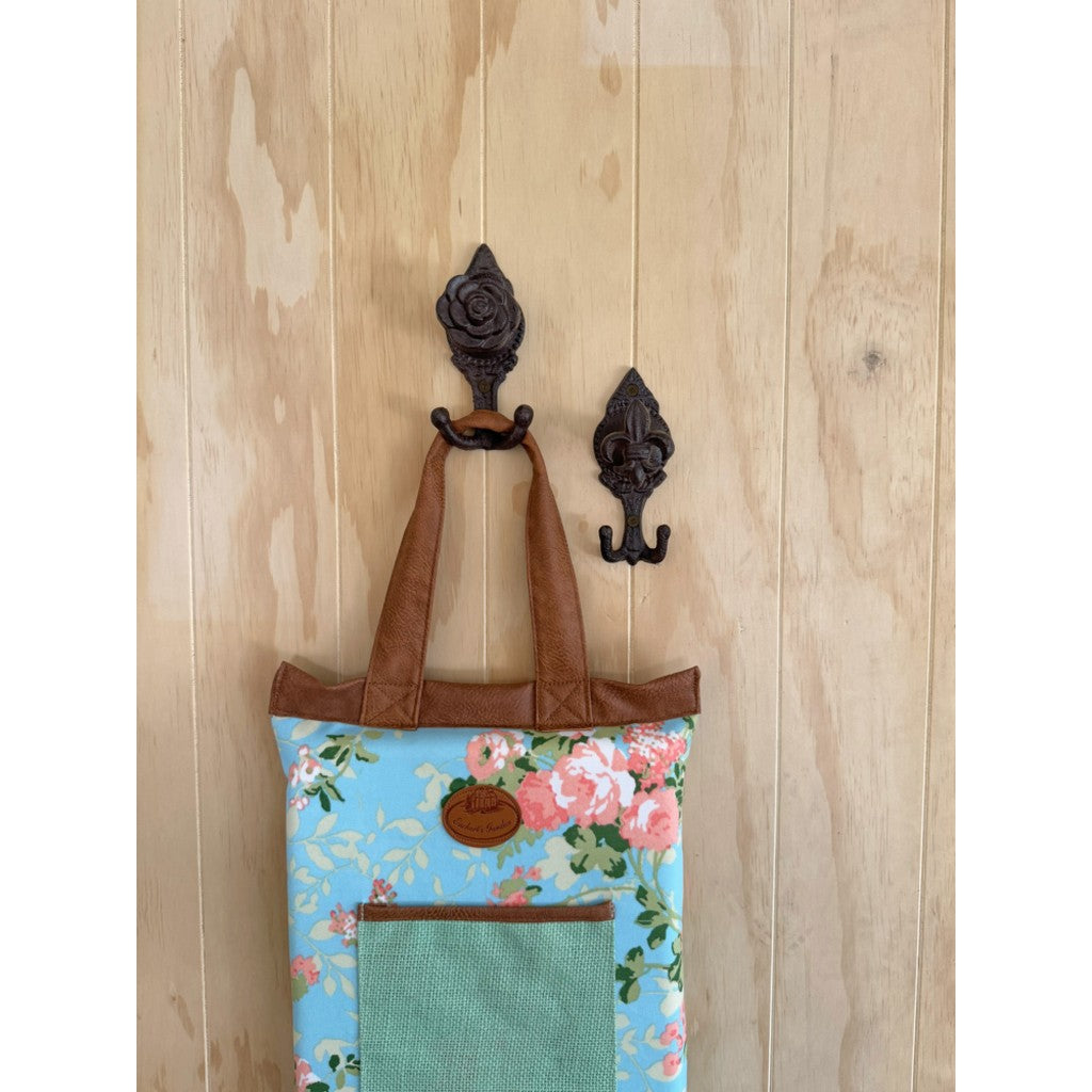 Cast iron flower hook holding a floral bag on a timber wall