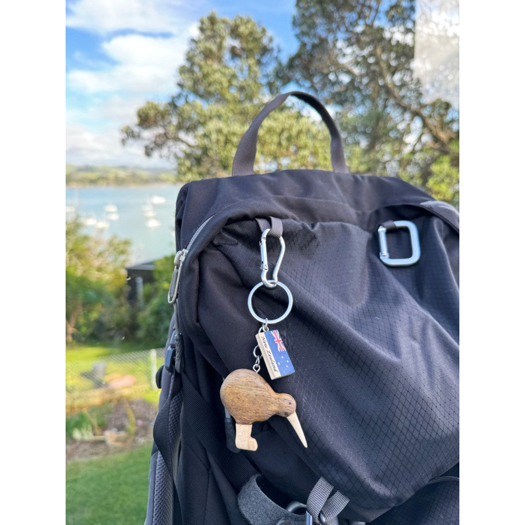 Wooden kiwi keyring clipped to a backpack