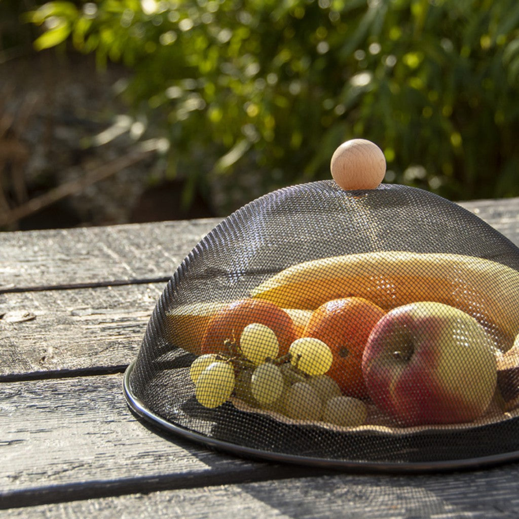 Mesh food cover protecting fruit on an outdoor table