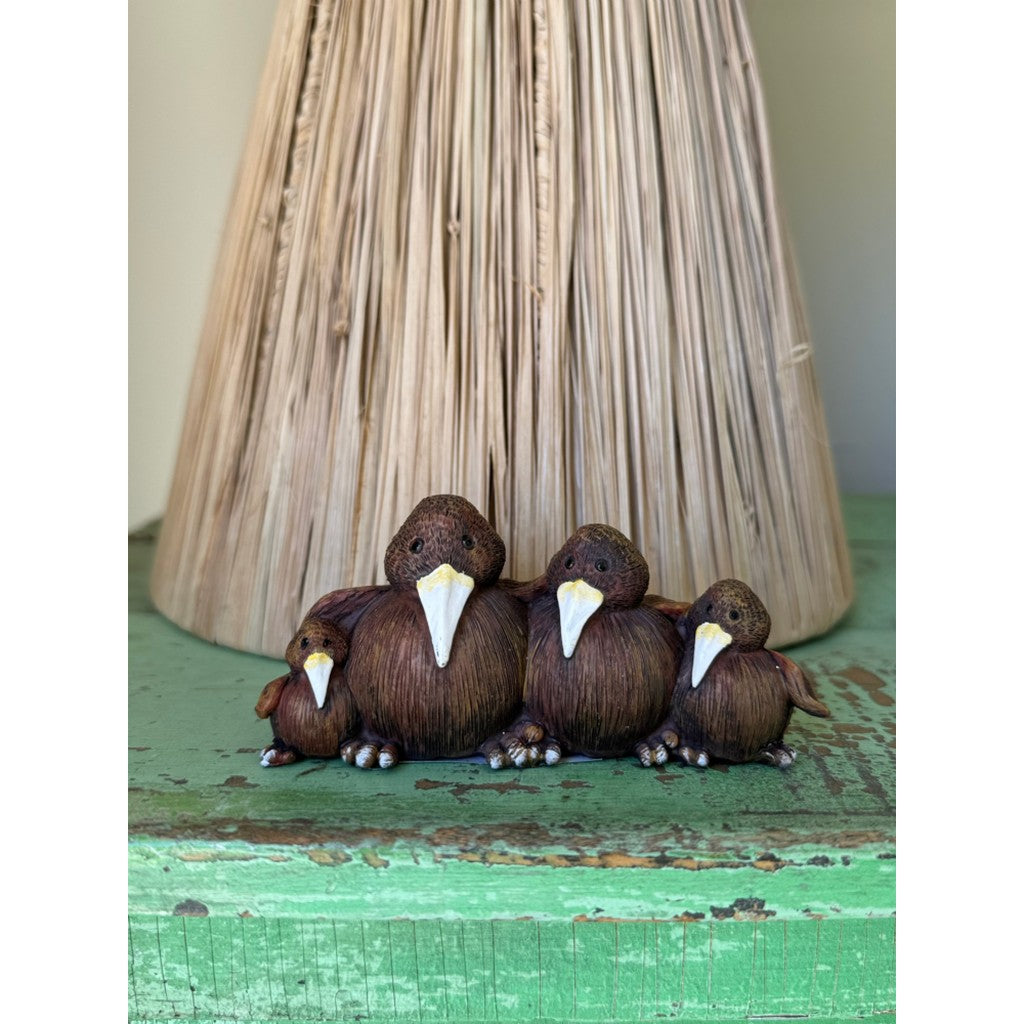 Kiwi family figurines beside a woven lamp