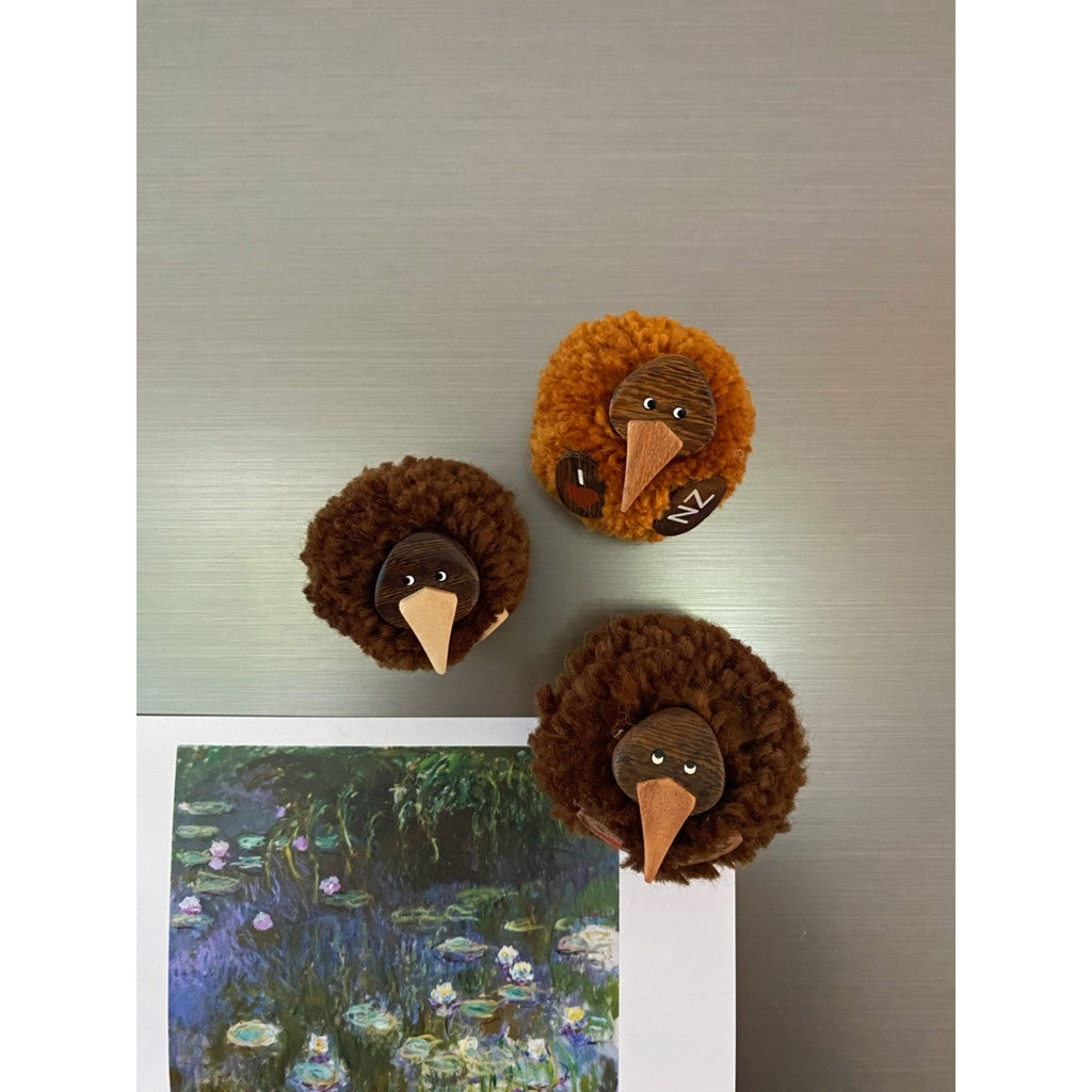 Pompom kiwi magnets on a fridge
