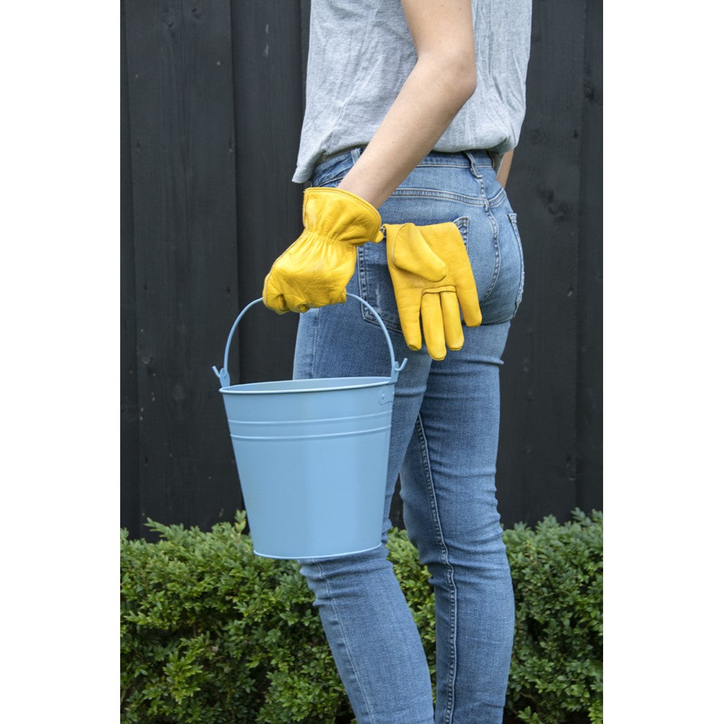 Gardener wearing yellow leather gloves carrying a bucket
