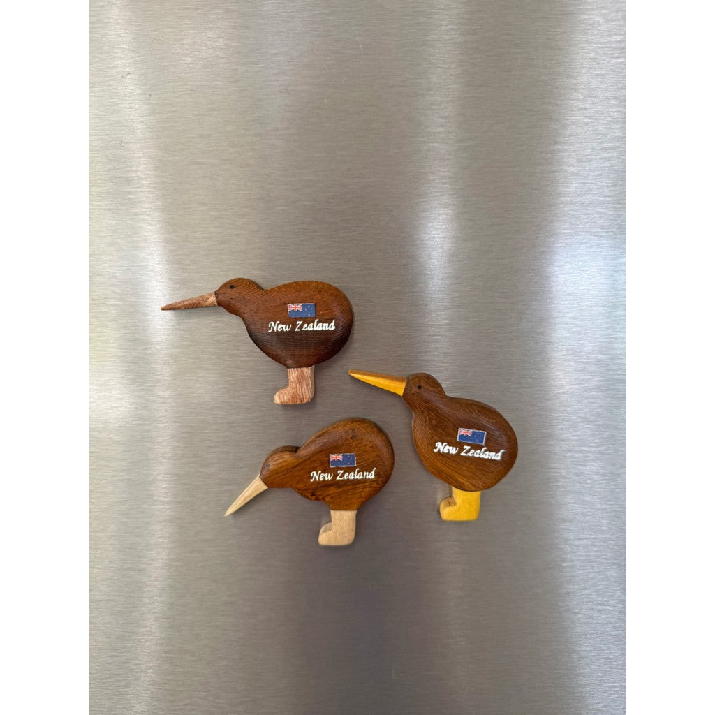 Wooden kiwi magnets on a fridge door