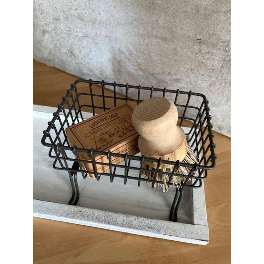 Pot brush in a wire basket by the sink