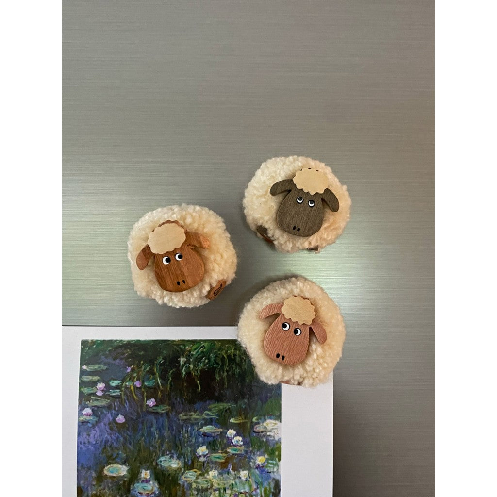 Pompom sheep magnets on a fridge