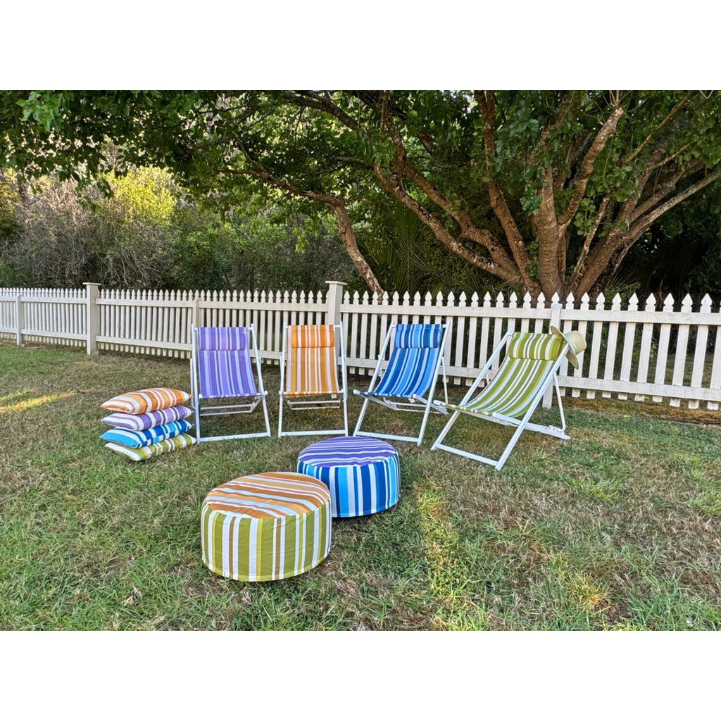 Striped pouffes and deck chairs on a lawn