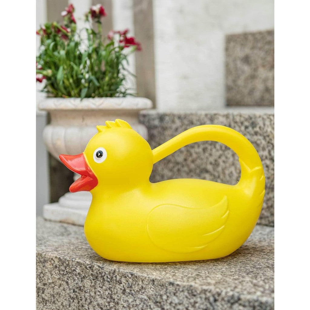 Yellow duck watering can beside a potted plant