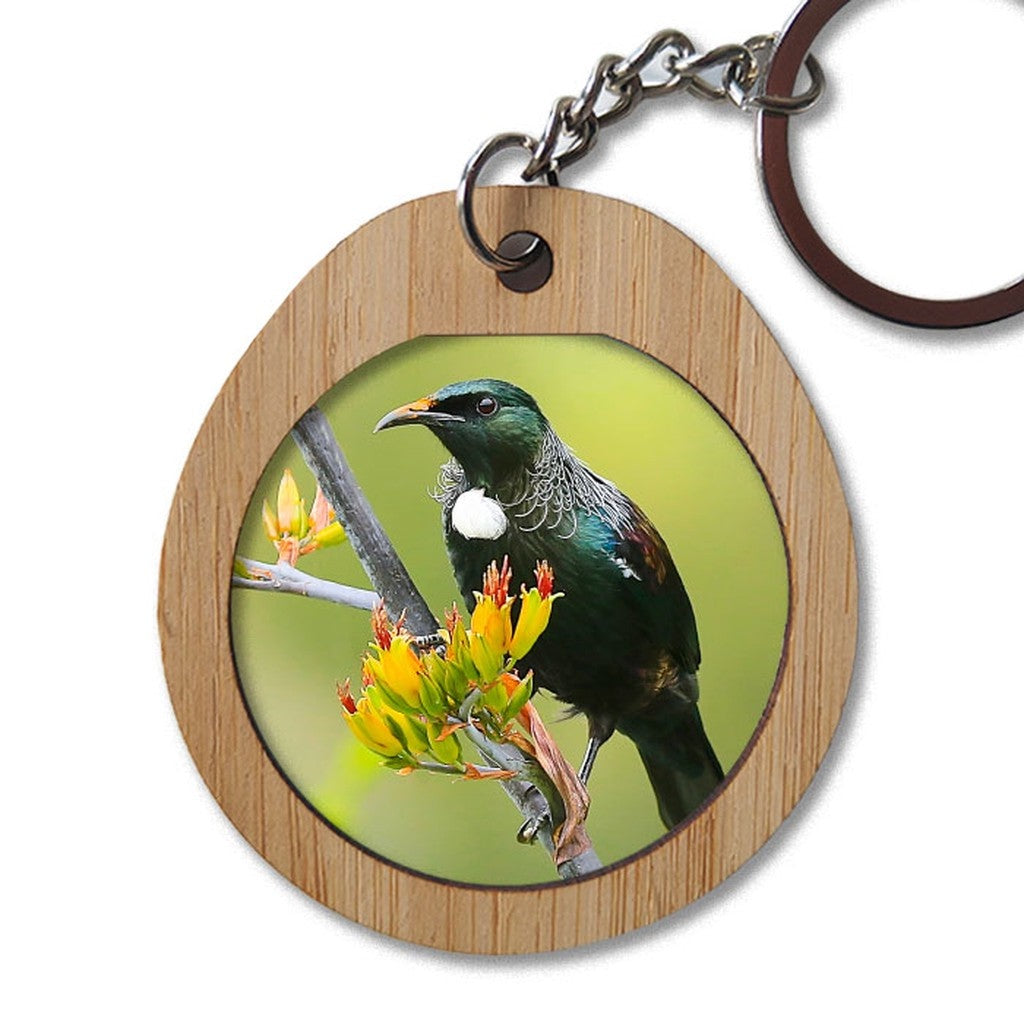 Pikitia bamboo key ring with a photo of a tūī feeding on flax